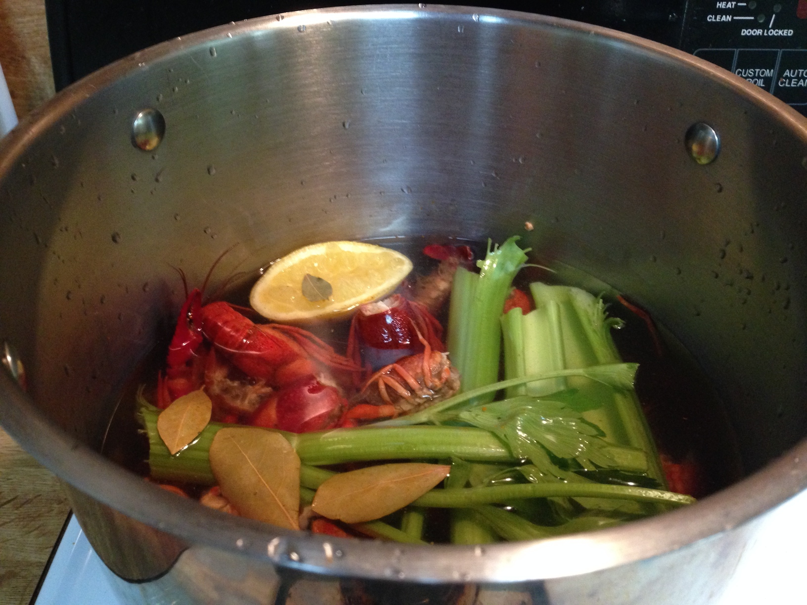 Stockpot with simmering crawfish bodies.